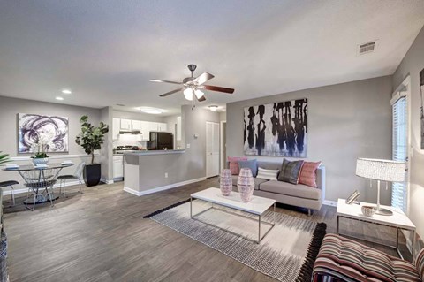 A modern living room with a ceiling fan and a striped rug.