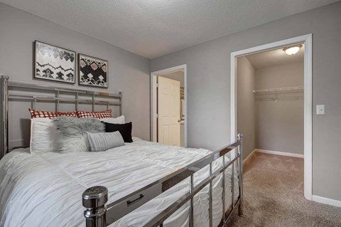 A bedroom with a white bed and a white door.