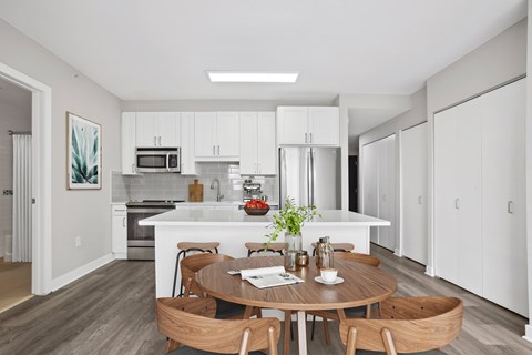 A modern kitchen with a dining table set for two.