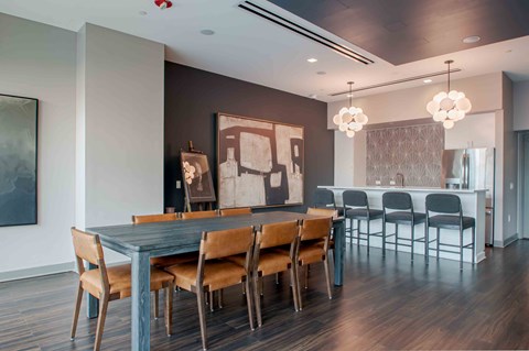 A modern dining room with a dark wooden table and chairs.