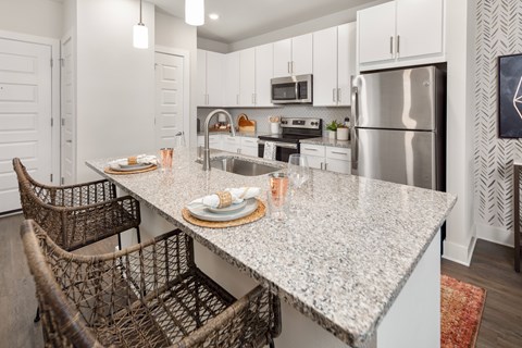 A kitchen with a granite countertop and a refrigerator.