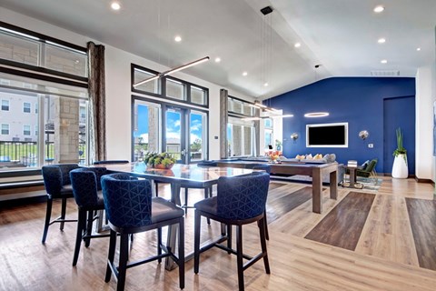 A modern dining room with a dark blue chair set and a wooden floor.