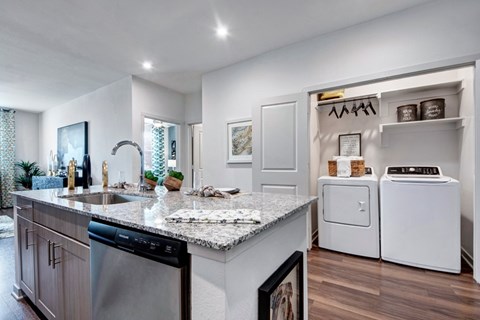 A modern kitchen with a granite countertop and stainless steel appliances.