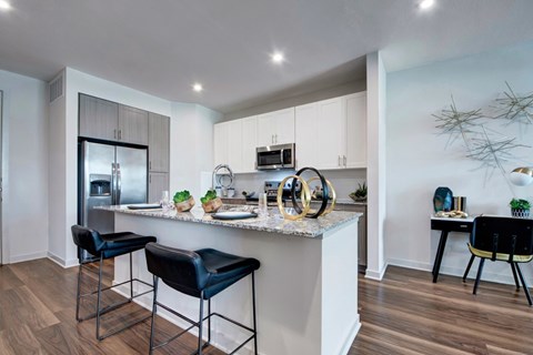 A modern kitchen with a bar area and a dining table.