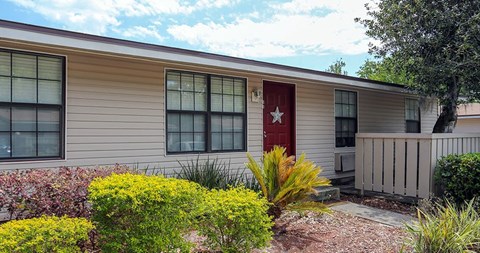 A house with a red door and a small garden in front.