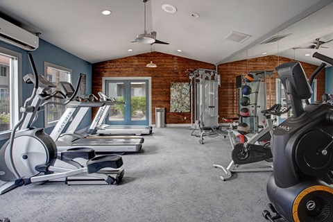 A spacious gym with treadmills, elliptical machines, and other exercise equipment.