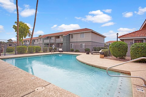 A swimming pool in a residential area with houses in the background.