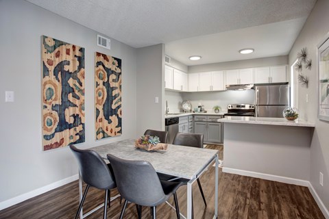 A kitchen with a dining table and chairs.