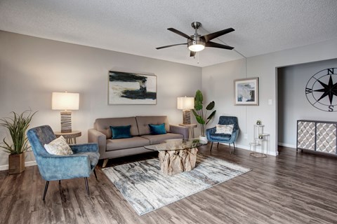 A living room with a blue chair and a beige couch.
