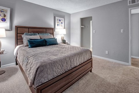 A bedroom with a large bed and two lamps.