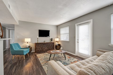 A living room with a blue chair, a brown cabinet, and a white couch.