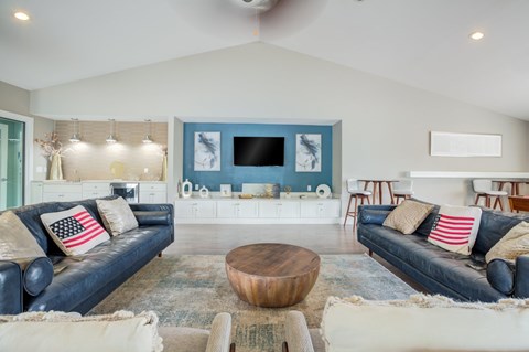 A living room with a black couch and a wooden coffee table.