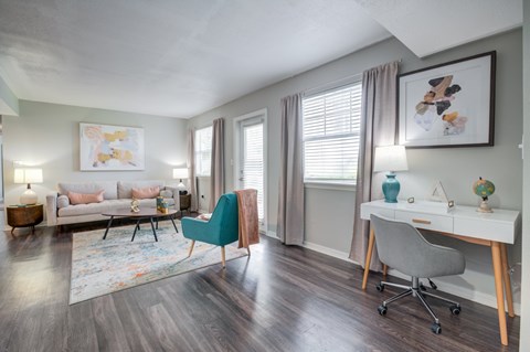 A room with a blue chair and a white desk.