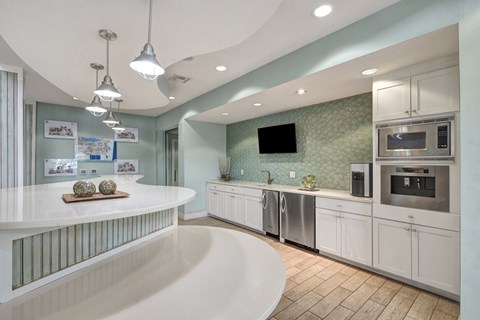 A modern kitchen with a curved counter and stainless steel appliances.