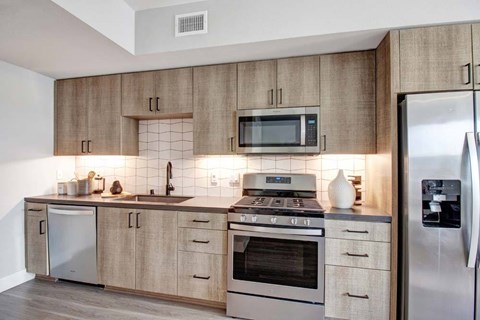 A modern kitchen with wooden cabinets and stainless steel appliances.