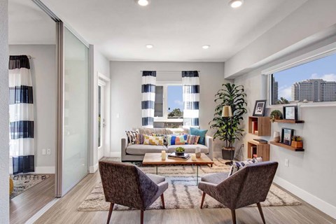 A modern living room with a glass door leading to a balcony.