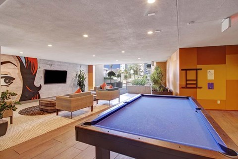 A pool table in a room with a painting on the wall.