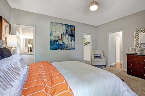 A bedroom with a large bed and a painting on the wall.