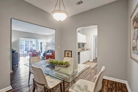 A dining room with a glass table and chairs.