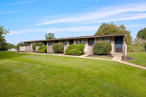 A long building with bushes in front of it.