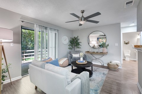 A living room with a white couch and a ceiling fan.