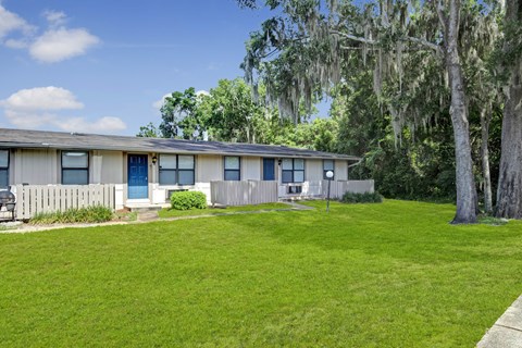 A house with a blue door and a green lawn.