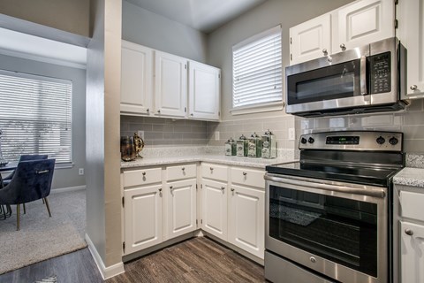 A kitchen with white cabinets and stainless steel appliances.