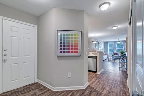 A room with a white door and a picture of a color palette on the wall.