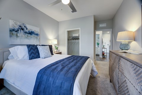 A bedroom with a large bed and a ceiling fan.