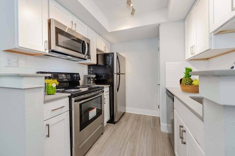 A kitchen with a stove, oven, microwave, and refrigerator.