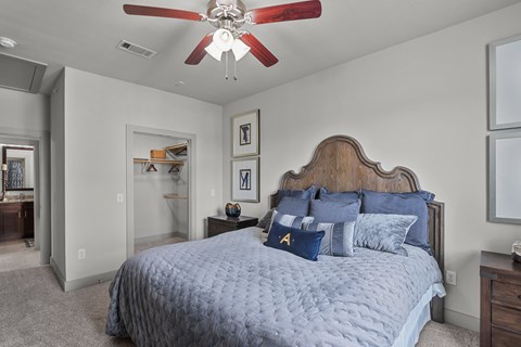 A bedroom with a large bed and a ceiling fan.
