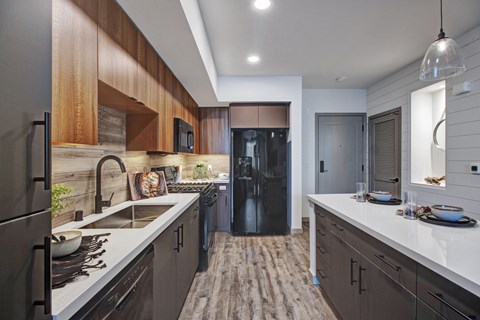 A modern kitchen with dark wood cabinets and a white countertop.