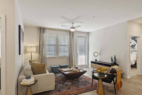 A living room with a couch, a coffee table, and a ceiling fan.