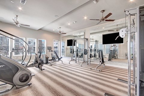 A gym with treadmills, elliptical machines, and other exercise equipment.