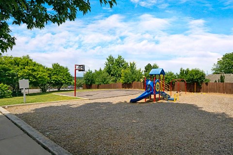 A playground with a blue slide and a red sign with an arrow.