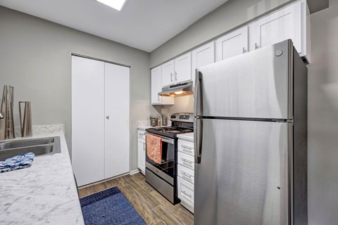 A modern kitchen with a refrigerator, sink, and cabinets.