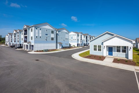 A large building complex with a parking lot in front.