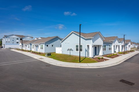 A row of houses with a clear blue sky above them.