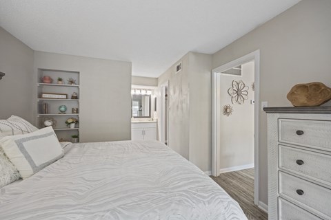 A bedroom with a large bed and a dresser.