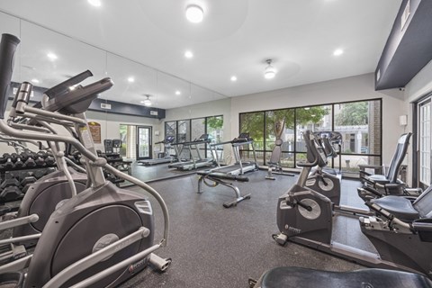 A gym with treadmills, elliptical machines, and other exercise equipment.