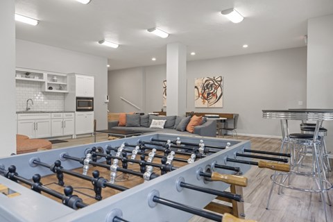 A foosball table is in the middle of a living room.