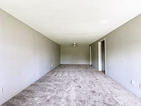 A long, empty hallway with carpeted floors and white walls.