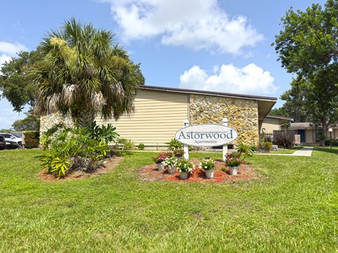 A sign that says Astorwood Apartments is in front of a building.