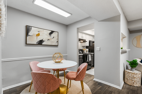 A dining room with a white table and chairs.
