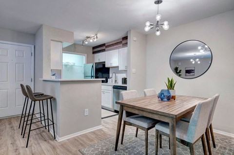 A kitchen with a dining table and chairs.