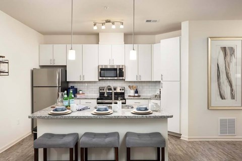 A kitchen with a table set for two and a framed picture on the wall.