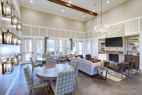 A large, well-lit dining room with a stone fireplace and a television.