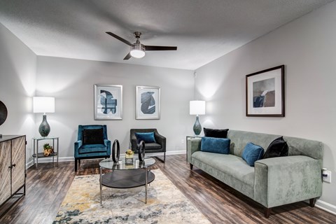 A living room with a grey couch, a blue chair, and a coffee table.