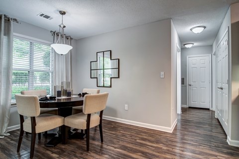 A dining room with a table and chairs.
