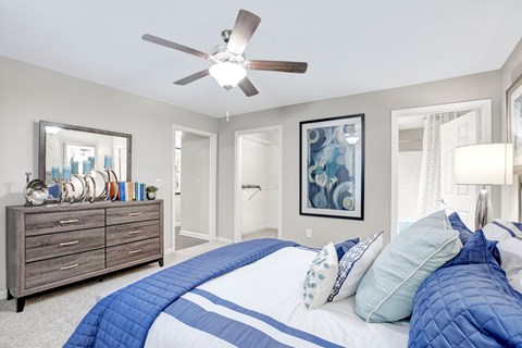 A bedroom with a large bed and a ceiling fan.
